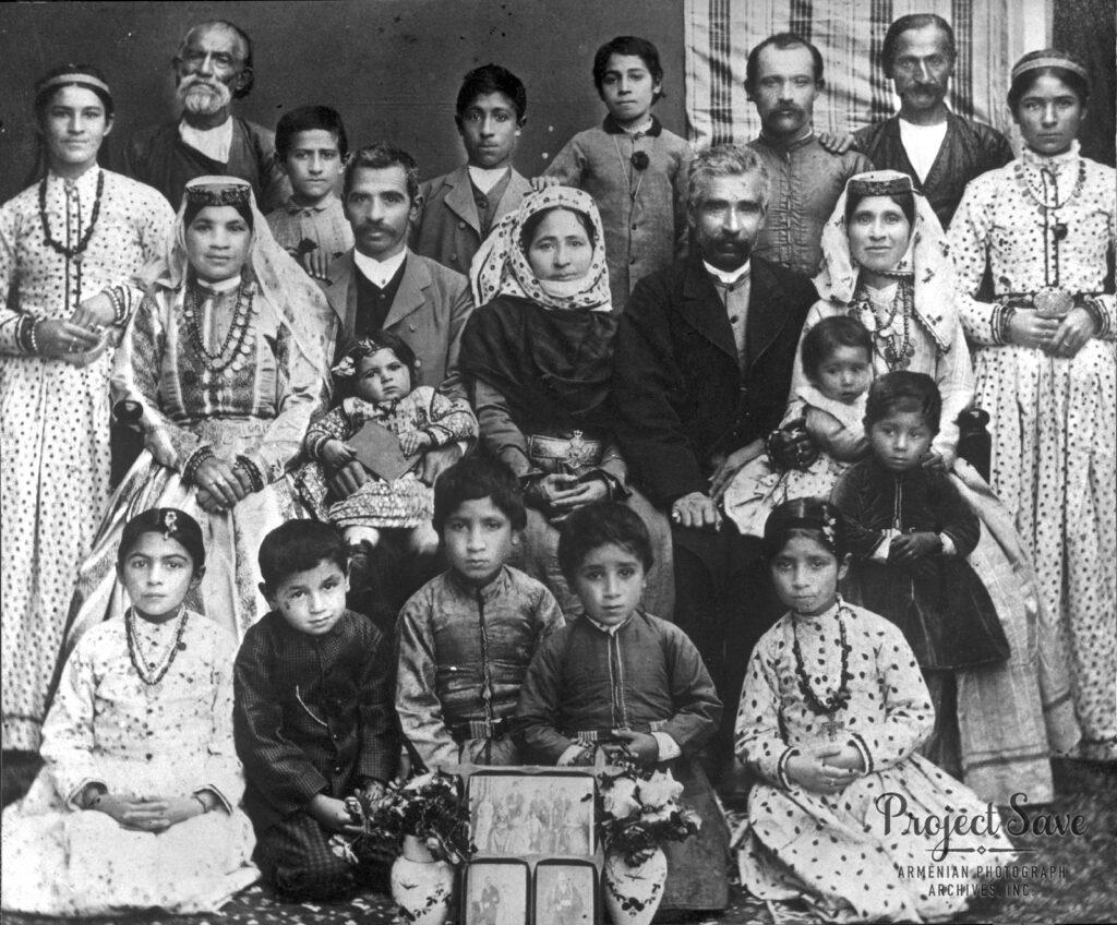 Black and white photo of a large family group. The young children are seated in front of the adults.