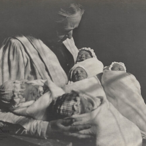 A woman holding five babies in her arms